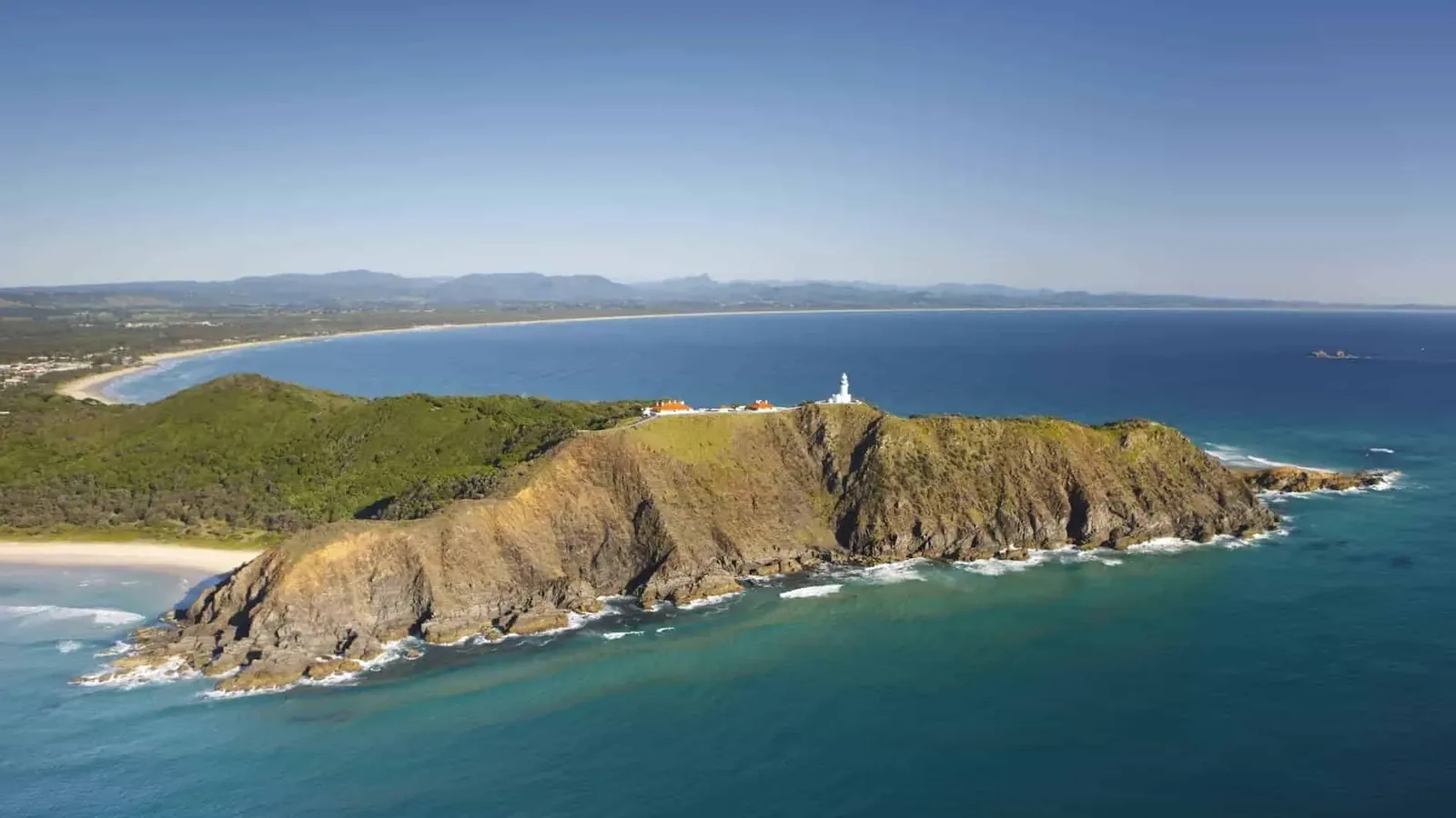 Aerial view of Cape Byron with its lighthouse and the long curve of Byron Bay behind