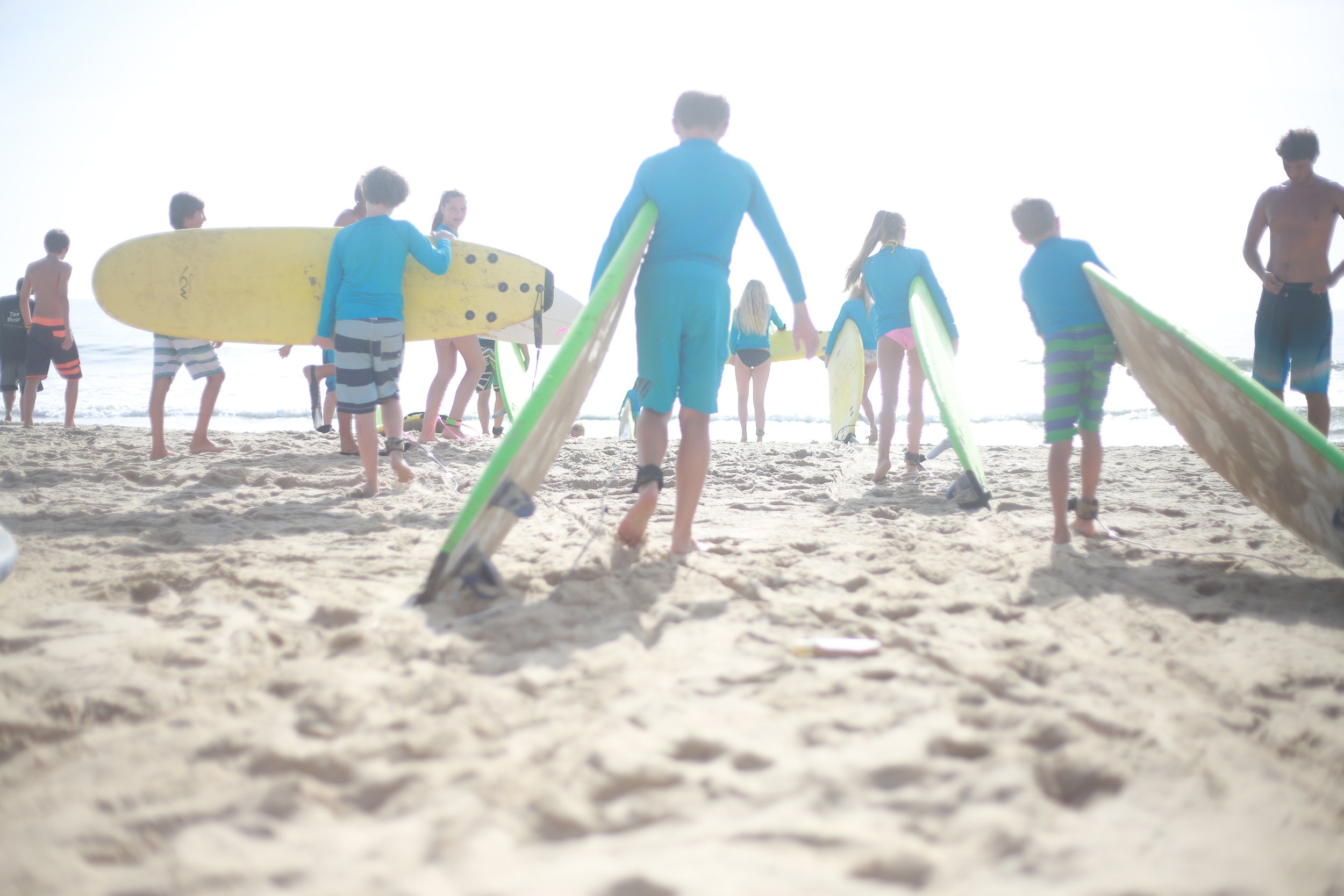 Kids holding surf boards at the beach